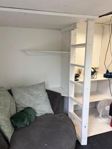 Habitación con sofá y litera en The Cosy Garden Hideout, en Peterborough