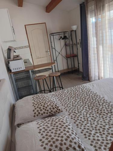 a bedroom with a bed and a table and chairs at Studio sympa meublé avec parking privé et piscine in Manosque