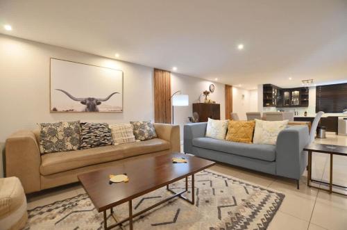 un soggiorno con un divano e un tavolo di Elegant Contemporary Apartment at Eden on the Bay a Big Bay