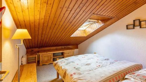 a bedroom with a bed and a ceiling with a window at Le Refuge du Forchat in Bellevaux