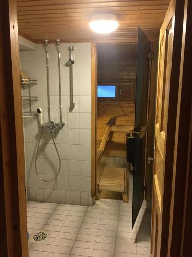 a bathroom with a shower and a tub at Immelmökit in Levi