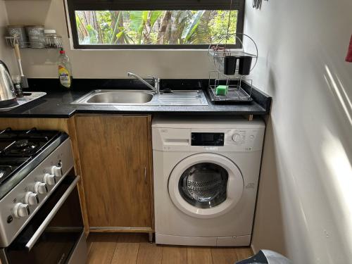eine kleine Küche mit Spüle und Waschmaschine in der Unterkunft Khaled Estate Cottages in Hillcrest