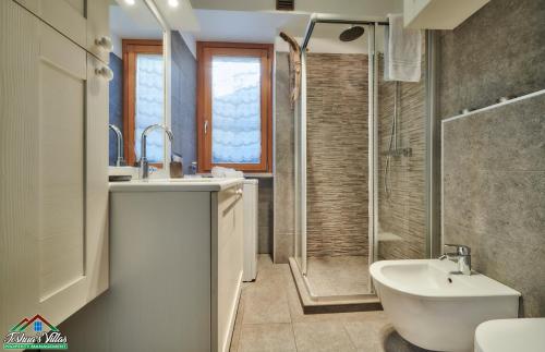 a bathroom with a sink and a shower and a toilet at Sunset Apartment with Air Conditioning and Lake View in Perledo