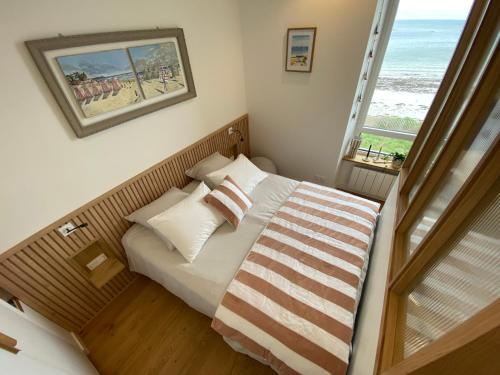 ein Schlafzimmer mit einem Bett mit Blick auf das Meer in der Unterkunft Suite hôtelière face à la mer in Santec