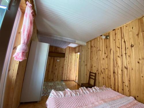 a bedroom with wooden walls and a bed in a room at Guest House Mari in Ureki