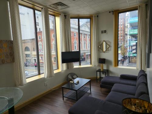 a living room with a couch and a tv at Stay Pittsburgh in Pittsburgh