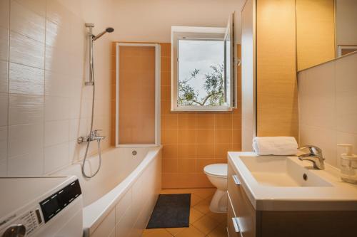 a bathroom with a tub and a toilet and a sink at Casa Lutoma in Kmeti