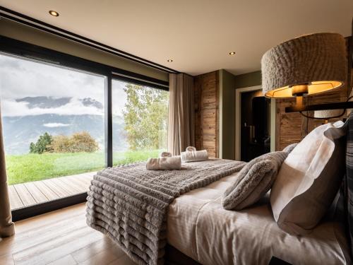 ein Schlafzimmer mit einem großen Bett mit einem großen Fenster in der Unterkunft Splendide chalet 6 pièces, jacuzzi et sauna, proche pistes à La Plagne Montalbert - FR-1-755-24 in Aime La Plagne