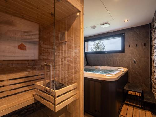 ein Badezimmer mit Badewanne und Fenster in der Unterkunft Splendide chalet 6 pièces, jacuzzi et sauna, proche pistes à La Plagne Montalbert - FR-1-755-24 in Aime La Plagne