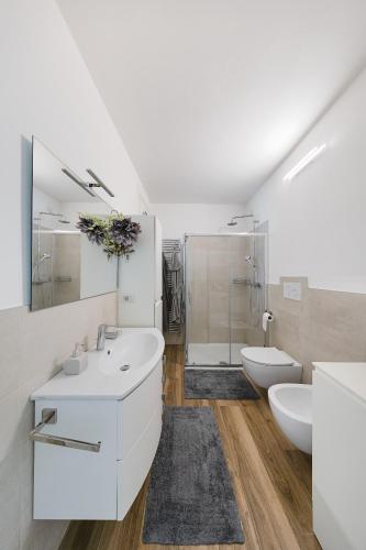 a white bathroom with a sink and a toilet at Vivere il Parco in Lonato