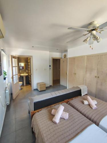 a bedroom with two beds and a ceiling fan at Natura Escapade Guesthouse in Torrox