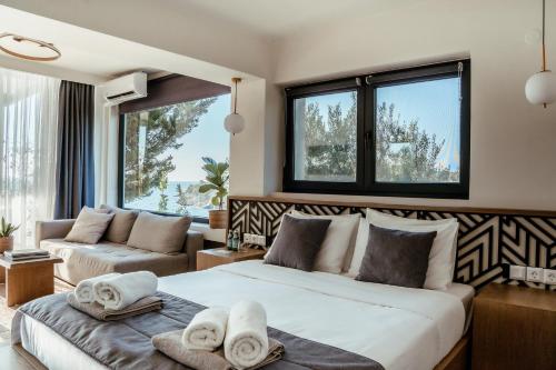 埃利亚Casa Bloo Adults Only的带床、沙发和窗户的卧室