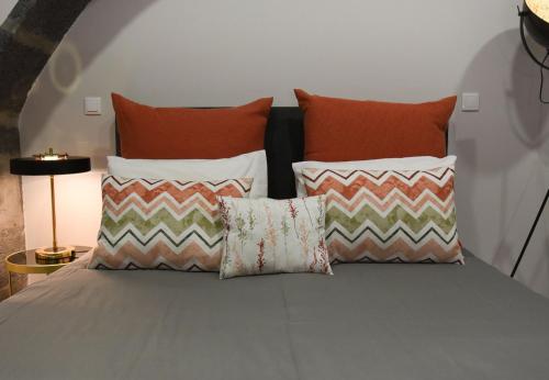 a bed with four pillows at GuestReady - Casa das Arcadas in Ponta Delgada