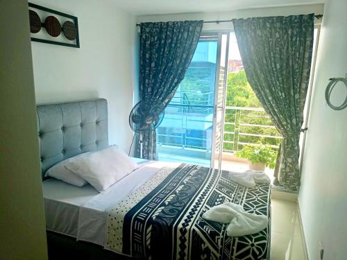 a bedroom with a bed and a large window at Apartamento con Piscina y Vista panoramica Anapoima Centro in Anapoima