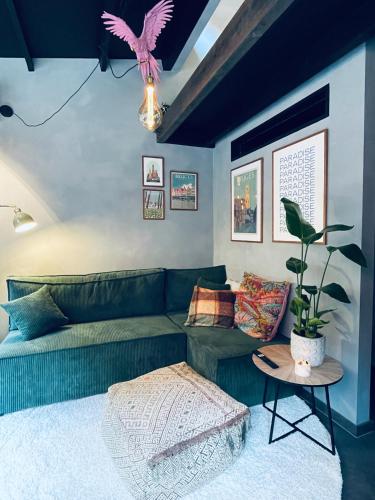 布鲁日Tiny House The Bird House的客厅里有一张绿色的沙发和一张桌子