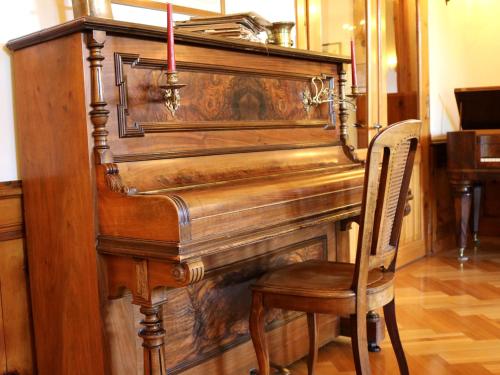 a wooden piano with a chair and two candles at Hotel Schweizerhof Sta Maria in Sta Maria Val Müstair