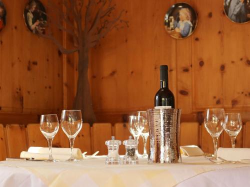 a bottle of wine sitting on a table with wine glasses at Hotel Schweizerhof Sta Maria in Sta Maria Val Müstair