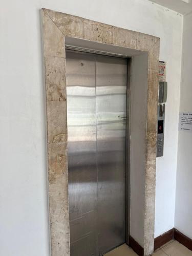 a elevator door in a room with a stone wall at Emeli Hotel Luxury Suites in Nairobi