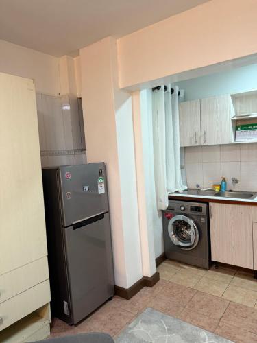a kitchen with a refrigerator and a washing machine at Emeli Hotel Luxury Suites in Nairobi