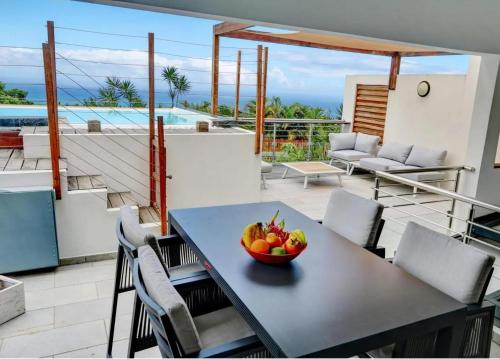 a bowl of fruit on a table on a balcony at Villa Swahili1 in Les Avirons