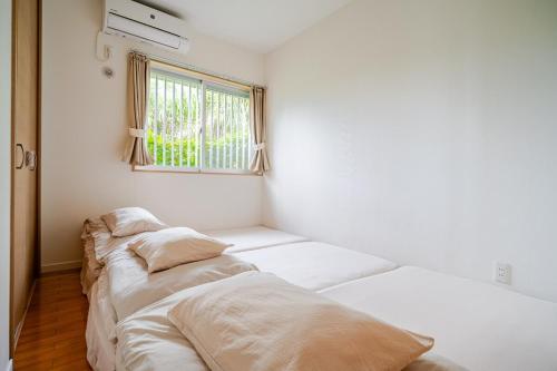 Postel nebo postele na pokoji v ubytování お子様連れ&動物好き大歓迎！産みたての卵を収穫体験できる宿