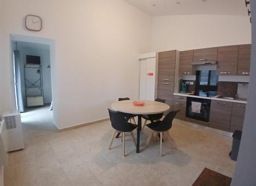 een keuken met een tafel en stoelen in een kamer bij Petite Maison dans le Gers 32 in Mouchan