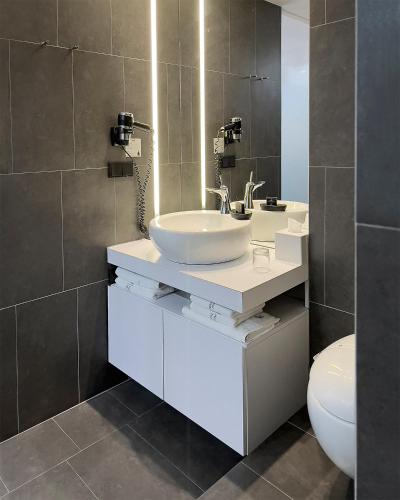 a bathroom with a sink and a toilet at Hotel Tomášov in Zlín