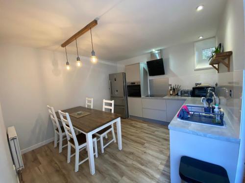 a kitchen and dining room with a table and a sink at Brylach Steading in Aberlour
