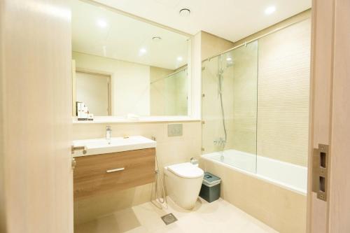 ein Badezimmer mit Waschbecken, Toilette und Badewanne in der Unterkunft Yas Golf Collection 1 BR Near Theme Parks in Abu Dhabi