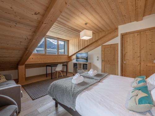 a bedroom with a large bed in a room with wooden ceilings at Duplex de standing 3 étoiles à Morzine, 100m des pistes, 9 pers., terrasse, garage, wifi inclus - FR-1-754-20 in Morzine
