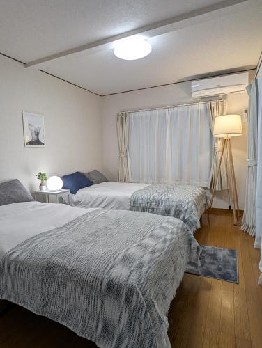 a bedroom with two beds and a window at ann近島 in Gifu