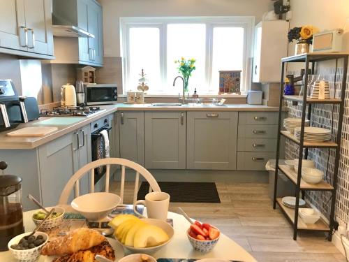 a kitchen with blue cabinets and a table with food on it at Charming Pembrokeshire Townhouse in Pembrokeshire