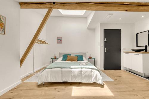 une chambre avec un grand lit dans une pièce blanche dans l'établissement Villa haut de gamme avec piscine, à Gagnac-sur-Garonne