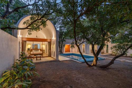 a house with a swimming pool and a tree at Le Casa Lion Resort A Premium Resort In Sasan Gir in Sasan Gir
