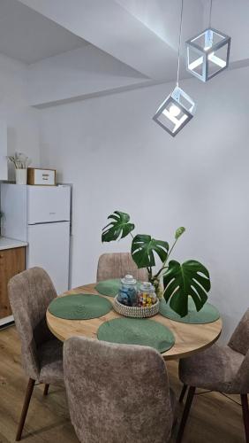 a dining room table with green cushions and a plant at Airport Nest Skopje in Petrovec