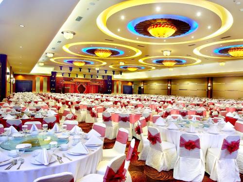 a large banquet hall with white tables and chairs at Aston Pontianak Hotel and Convention Center in Pontianak