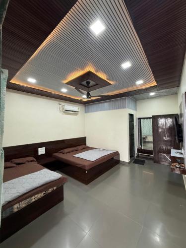 a large room with two beds and a ceiling at Patil residency in Matheran
