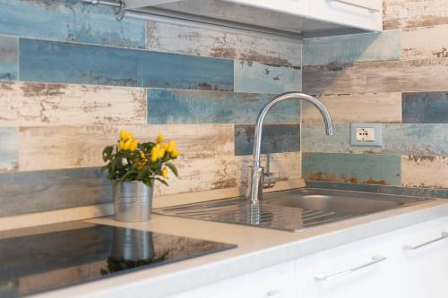 a kitchen with a sink and a vase with yellow flowers at Appartamento Pino Fetovaia by ElbaSummer Tour Operator in Fetovaia