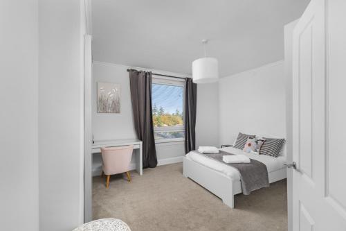 a white room with a bed and a window at Sidlaw View in Dundee