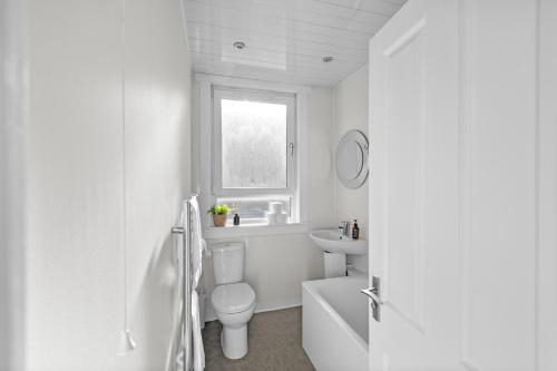 a white bathroom with a toilet and a sink at Sidlaw View in Dundee