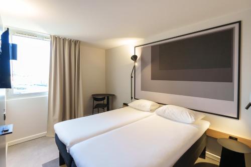 Ένα ή περισσότερα κρεβάτια σε δωμάτιο στο Ibis Laon - Hôtel Restaurant