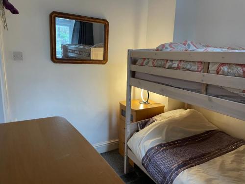 ein Schlafzimmer mit einem Etagenbett und einem Spiegel in der Unterkunft Apartment close to Pavilion gardens in Buxton