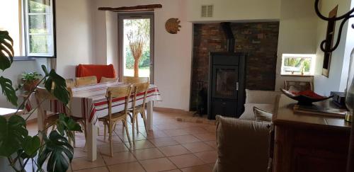 a living room with a table and a fireplace at Maison d'hôtes MOURENIA Aroue in Aroue