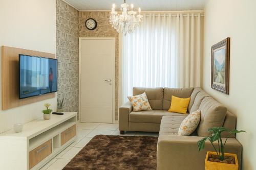 een woonkamer met een bank en een tv bij Cantinho da paz in Paranavaí