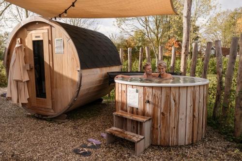 Dos niños bañándose en un jacuzzi en una sauna en Hofparken De Bergvennen, en Lattrop