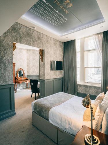 a bedroom with a bed and a desk and a chair at The Coal Exchange Hotel in Cardiff