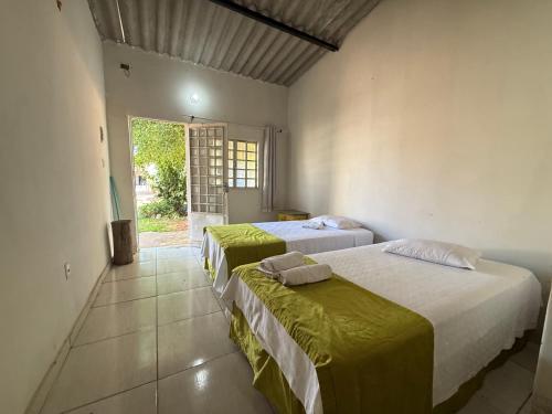 zwei Betten in einem Zimmer mit Fenster in der Unterkunft Caminito Brasília Hostel in Luziânia