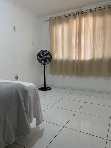 a white room with a fan and a window at Desfrutando de Arraial Apartamento in Arraial do Cabo