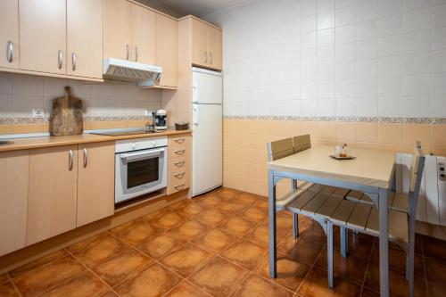 a small kitchen with a table and a refrigerator at Chicote Rural in Mota del Cuervo