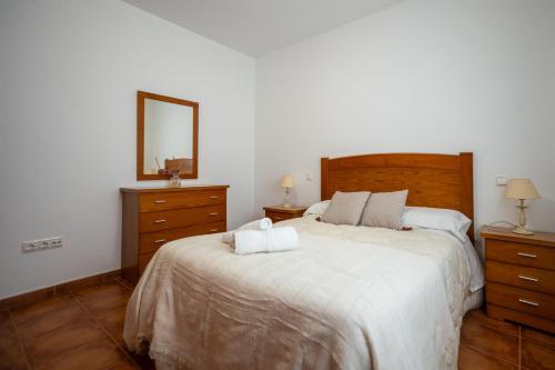 a bedroom with a large bed and a mirror at Chicote Rural in Mota del Cuervo